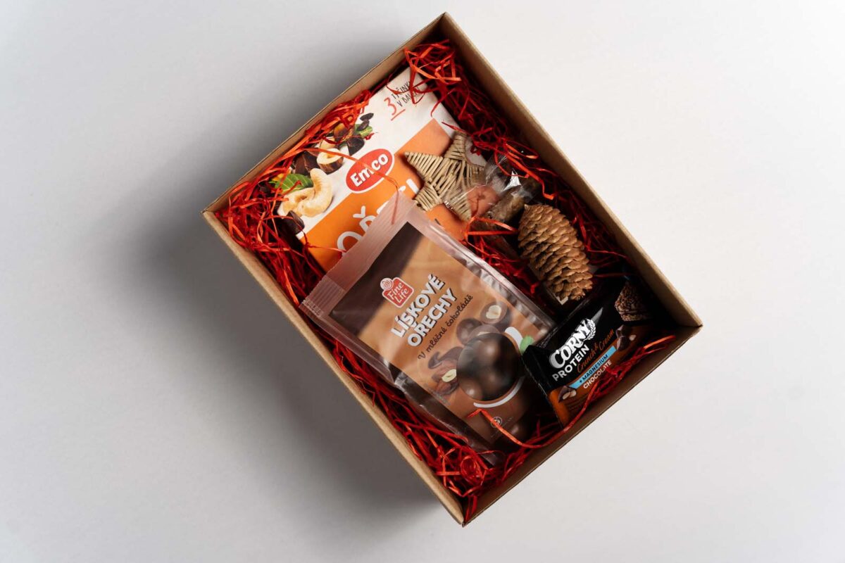 Darčekový balíček 7 obsahuje FineLife lieskové oriešky v ml. čokoláde 300g, Emco tyčinky orechy, kešu 35g x 3ks, Mr. Flapjack 120g čokoládový chip, Corny protein čokoládová tyčinka 35g, Ozdobná výplň